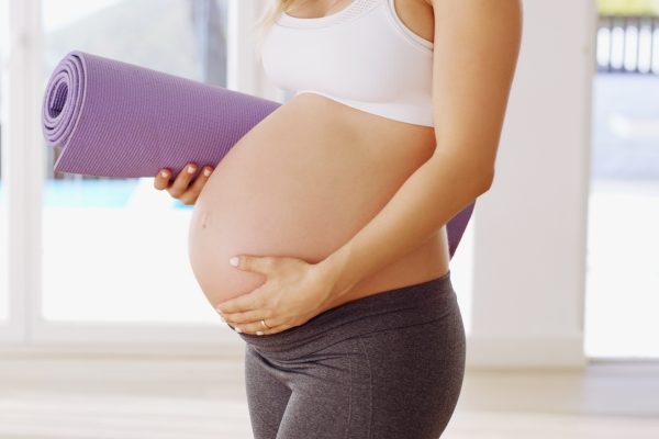 They told me yoga was good for the baby. Cropped shot of an unrecognizable young pregnant woman carrying a yoga mat.